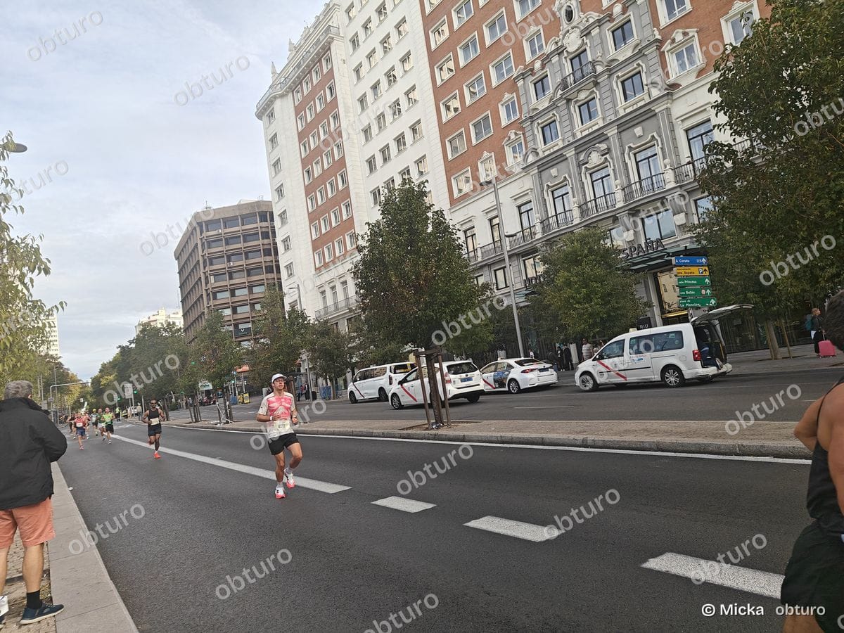 Un marathon en pleine ville avec des participants courant sur une route dégagée sous un ciel légèrement nuageux.